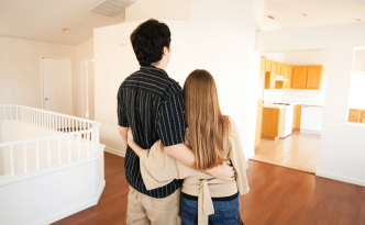 First time homeowners standing in their new home