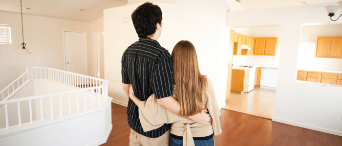 First time homeowners standing in their new home