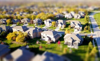 Beautiful Midwestern suburban home with a manicured green lawn and perfect landscaping on a bright, sunny day, representin...