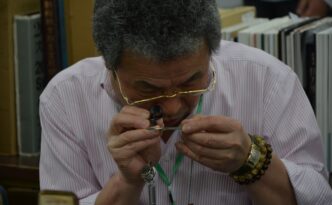 Person's hands using a magnifying glass to carefully examine the fine print on a legal document, symbolizing the due dilig...