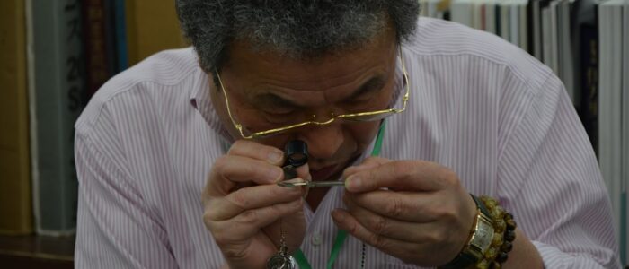 Person's hands using a magnifying glass to carefully examine the fine print on a legal document, symbolizing the due dilig...