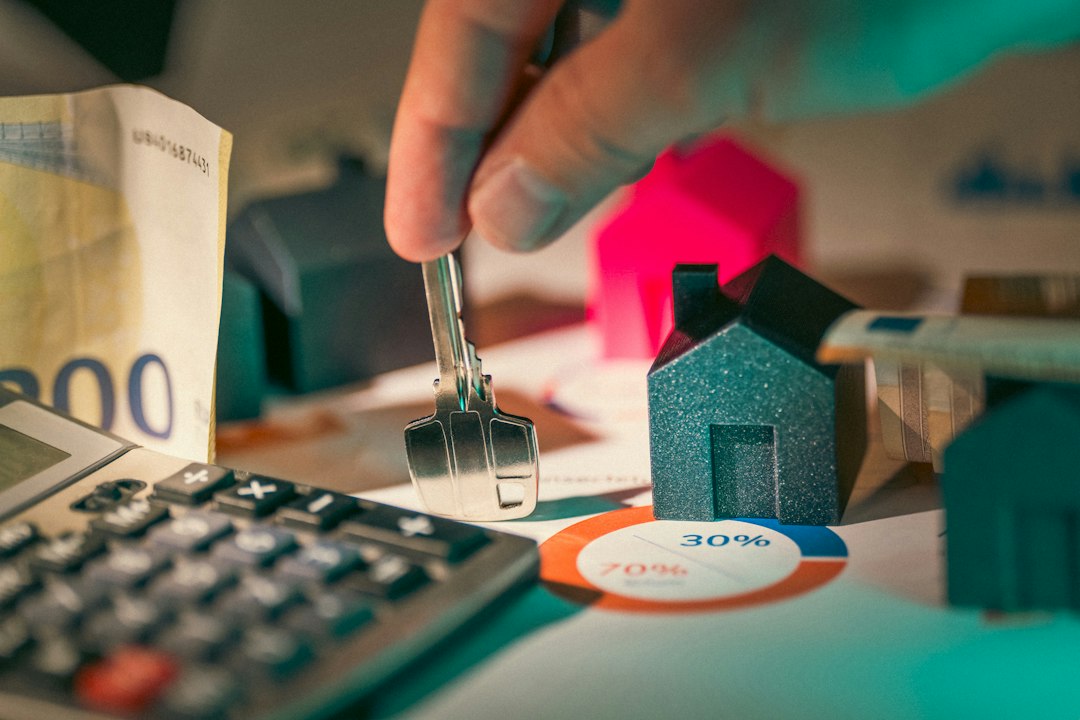 A minimalist arrangement of house keys, a calculator, and a pen on a desk, illustrating the process of calculating real estate commission savings.