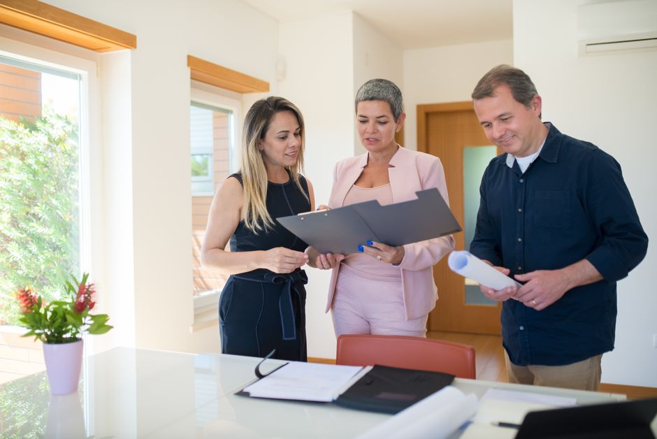 A real estate agent and a client having a warm, engaging conversation in a modern, sunlit home, showing the positive outcome of building client relationships.